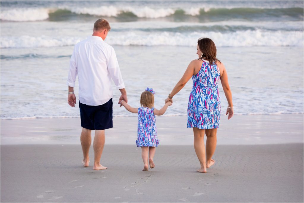 family walking holding hands on beach